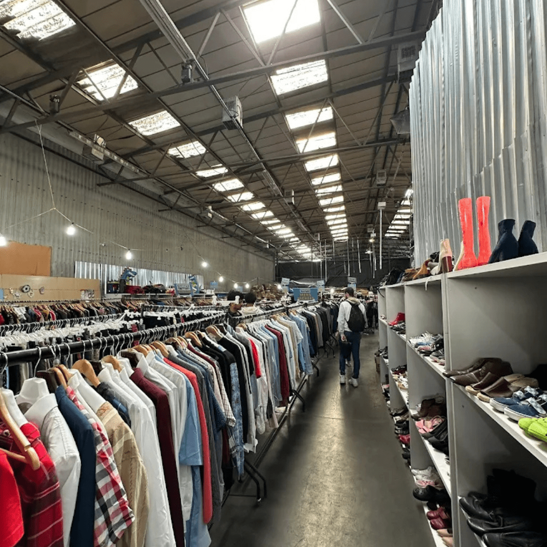 Rails of clothing inside the Thrift Factory warehouse